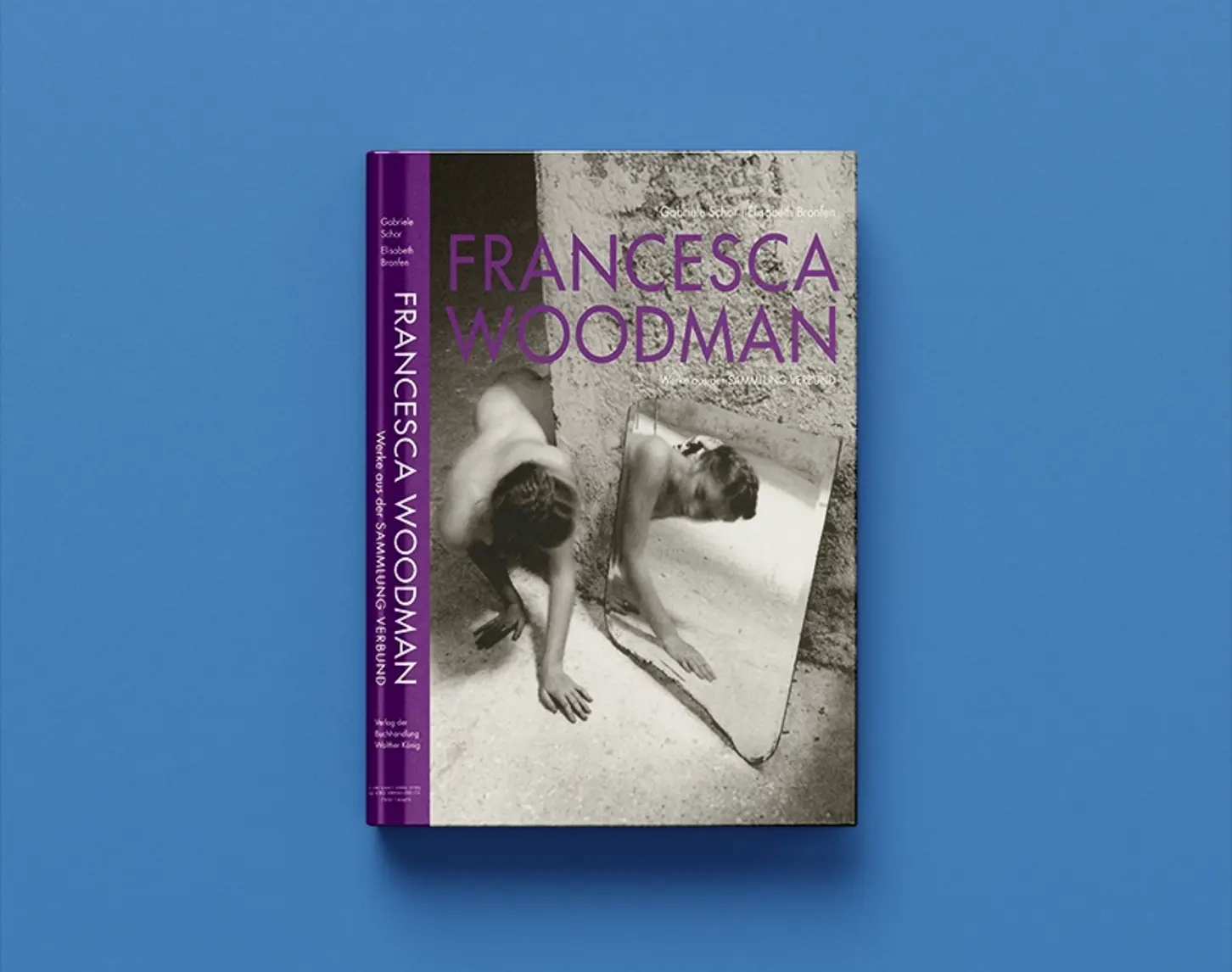 Wir sehen den Werkkatalog von Francesca Woodman aus dem Jahr 2014. Die Schrift ist in Violet gehalten. Das Cover zeigt einen Schwarz-Weiß-Fotografie einer Frau in einer rauen Betonumgeben und ihre Reflexion in einer große Spiegelscherbe.