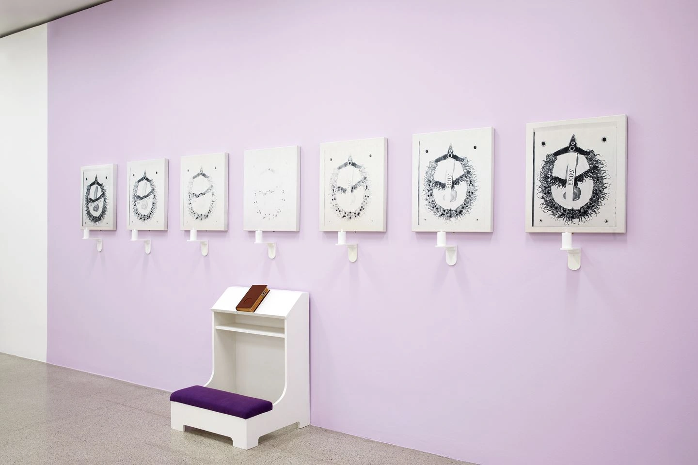 A row of drawings are depicted on a purple painted wall. In a horizontal line, the same drawing is depicted seven times in different contrasts.