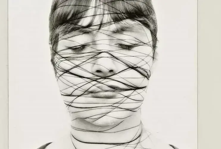 The picture shows an excerpt from the work “Self” by Annegret Soltau. She shows herself here in 3 black and white photographs with a constricted face.