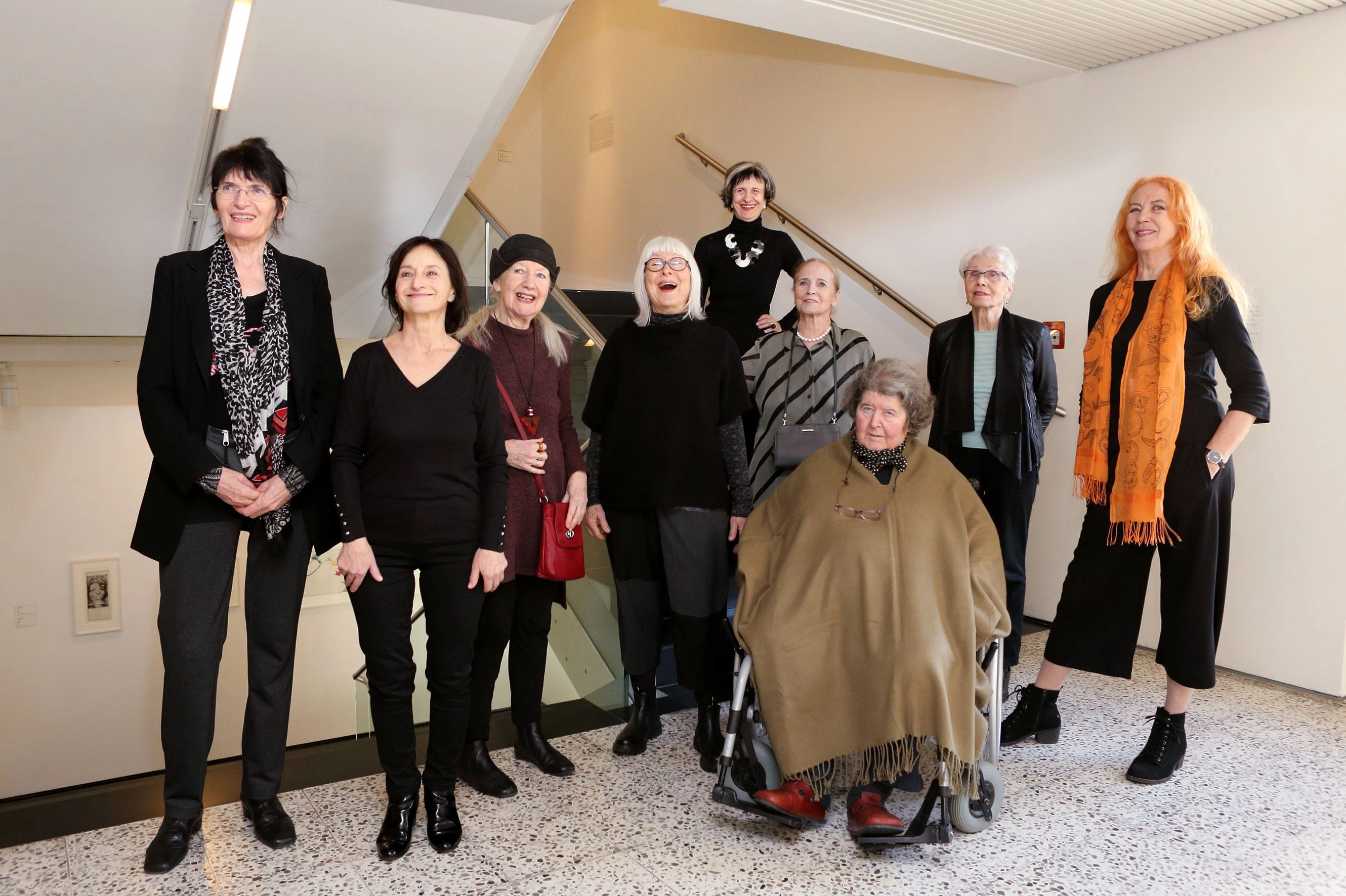 Nine women, presumably some of them artists themselves, pose for the camera.