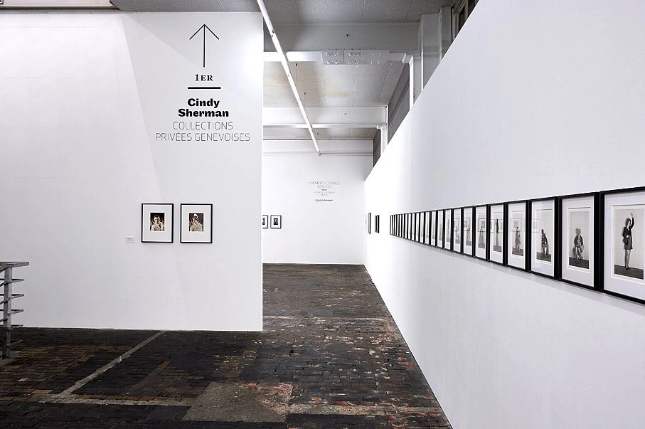 Gallery interior with a Cindy Sherman photography exhibition, with walls painted white featuring a series of framed photographs.