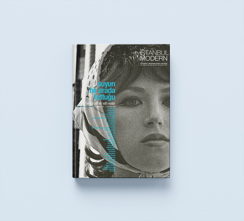 The exhibition catalog Held together with water from 2010 shows a black and white photo of a woman wearing a headscarf. Her bangs peek out from under her headscarf. She looks past the camera.