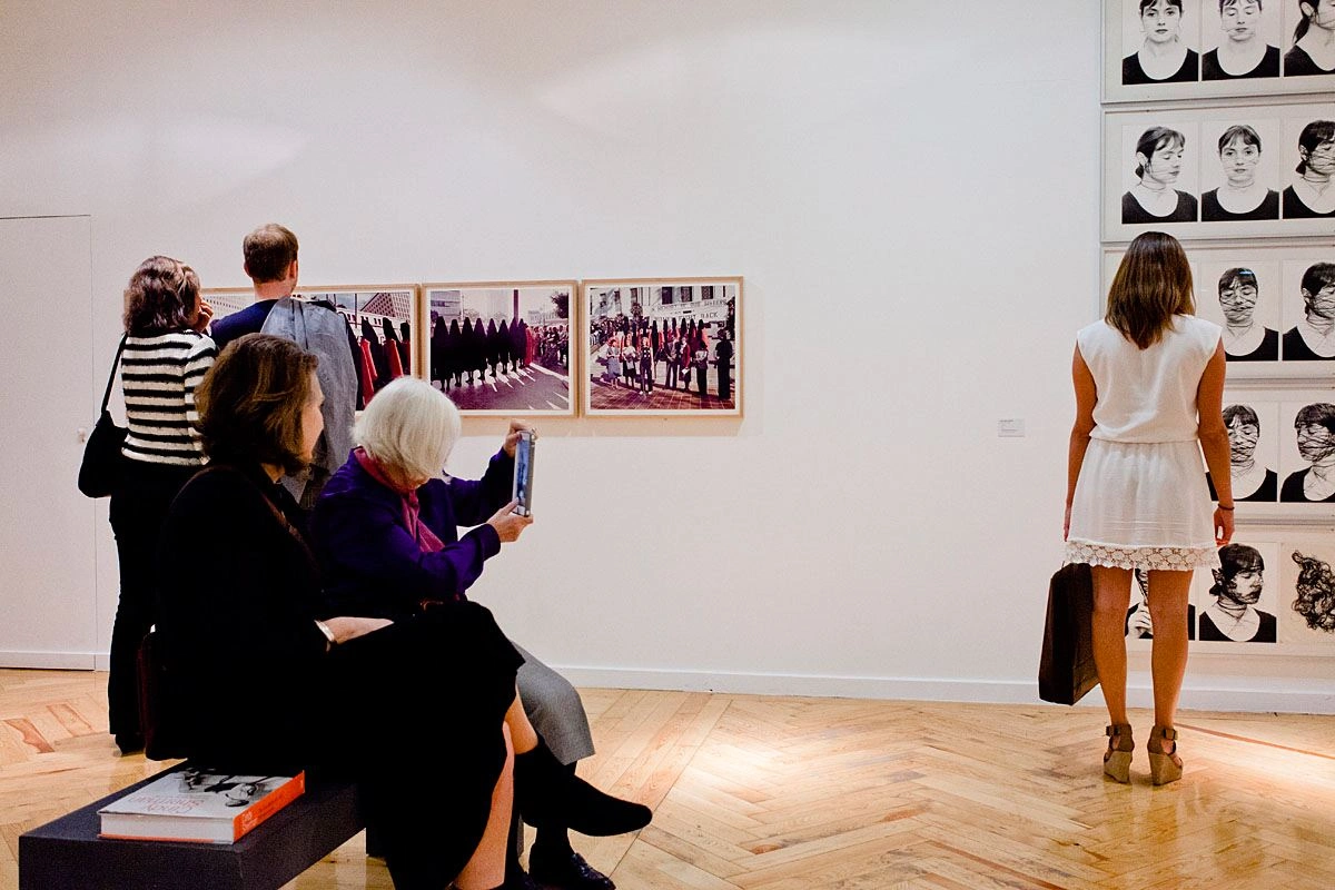 Auf einer weißen Ausstellungswand sind zwei Kunstwerke zu sehen. Es sind beides Fotografien.