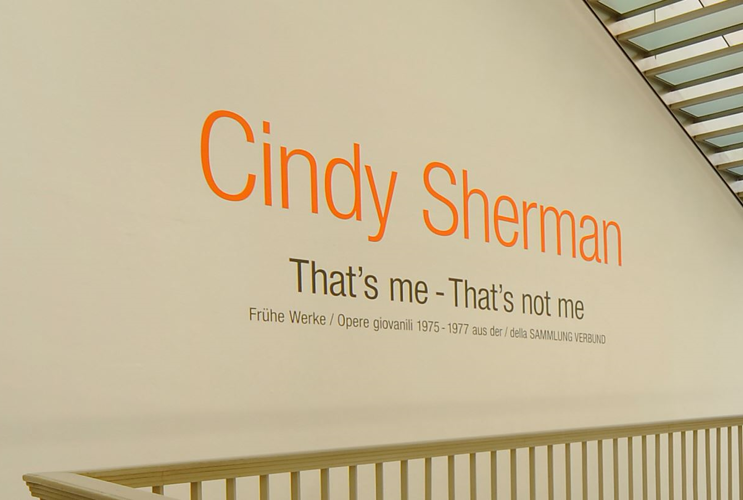 Brightly illuminated staircase with the lettering of the artist Cindy Sherman and the exhibition title.